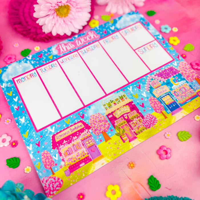 A detailed view of a weekly planner notepad with "this week" at the top and 3 spring themed bookshops along the bottom.