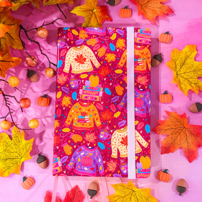 Pink, purple, and orange fall colored journal with sweaters, leaves, and books.