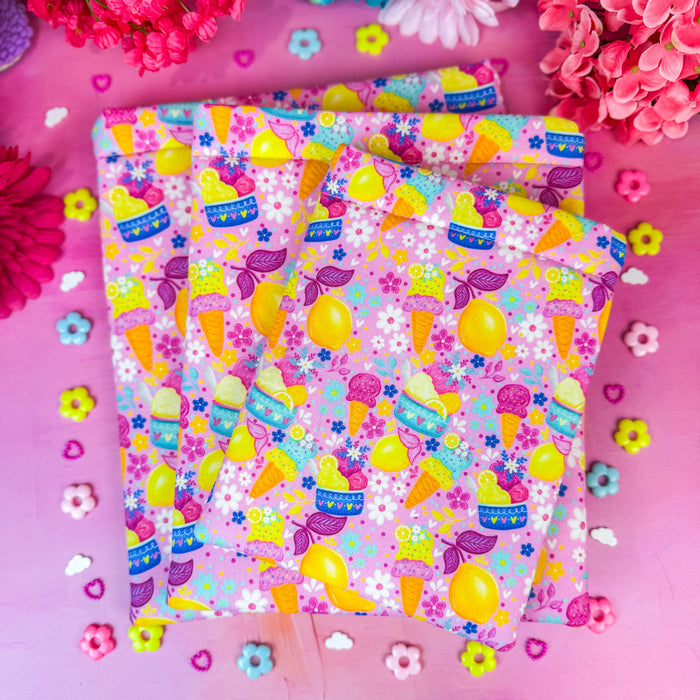Pink book sleeves featuring a lemon and ice cream pattern, against a pink backdrop.