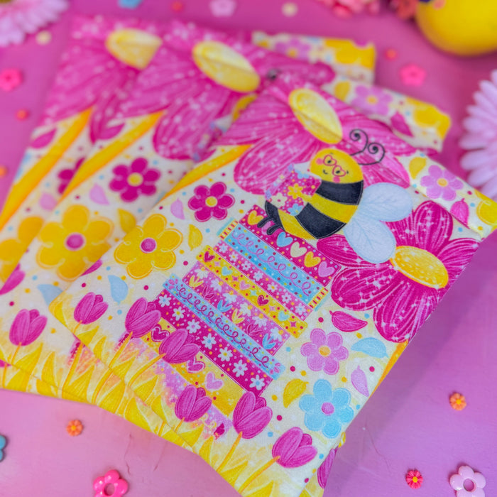 Colorful book sleeve with a bee design on a pink background