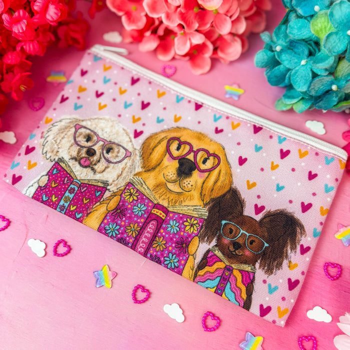 A rectangular zip pouch with a colorful illustration of three dogs wearing glasses, surrounded by bright pink and blue flowers on a pink surface.