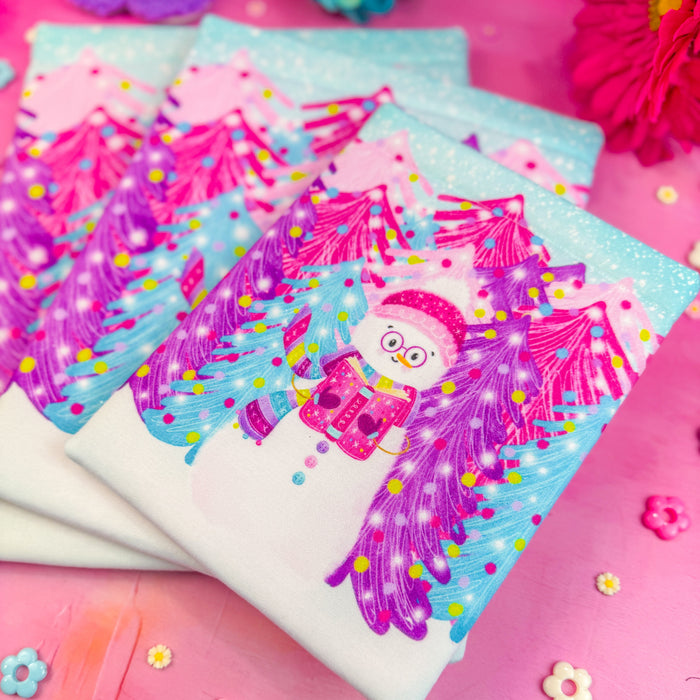 A detail shot of a stack of three winter snowman book sleeves on a bright pink background.