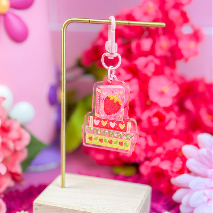 Decorative keychain on a stand with pink flowers in the background