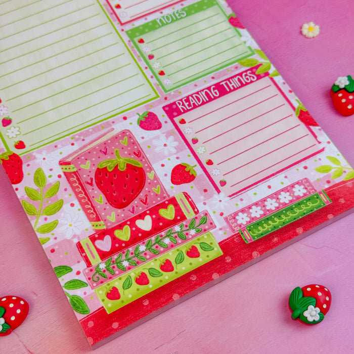 Notepad with strawberry-themed design on a pink background