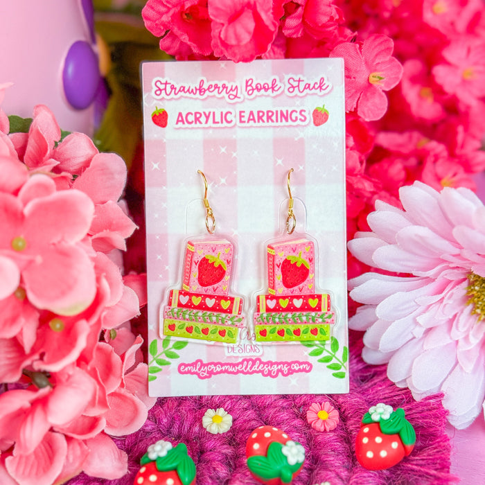 Acrylic earrings with strawberry design on a pink floral background