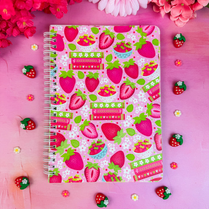 Notebook with strawberry pattern on a pink background with flowers and small strawberries